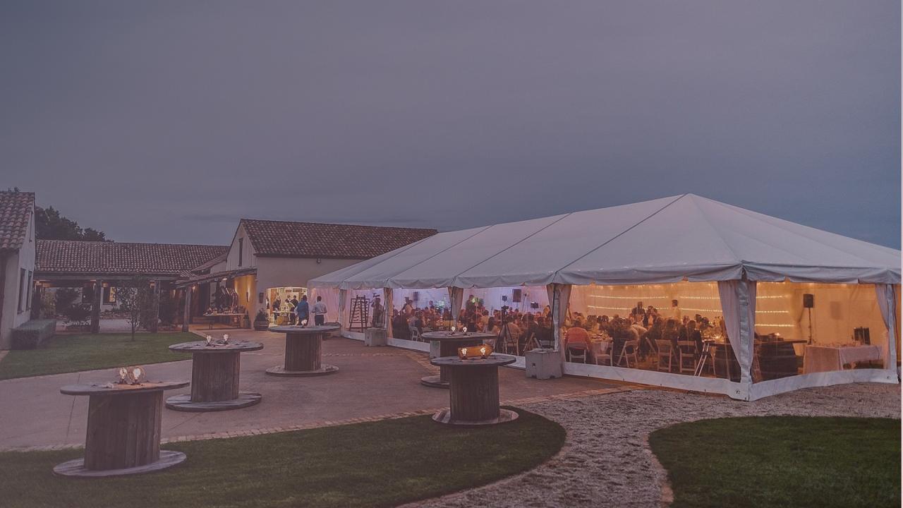 Sailcloth wedding marquee illuminated for an outdoor evening reception